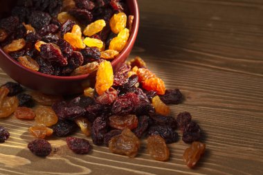 Kuru üzümler tahtadan bir masanın üzerinde kahverengi bir dikişle.