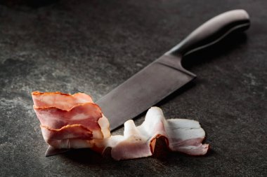 Mutfak bıçağında domuz pastırması. Greystone arkaplanı.