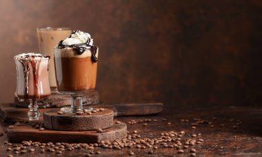 Kahverengi arka planda kremalı kahve ve çikolata içecekler. Cpoy alanı.