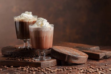 Kahverengi arka planda kremalı kahve ve çikolata içecekler..