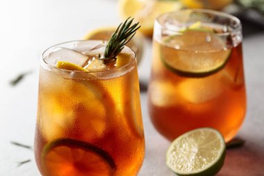 Limonlu buzlu çay, limon ve biberiye dallarıyla süslenmiş buz. Turunçgil dilimli donmuş bardaklar..