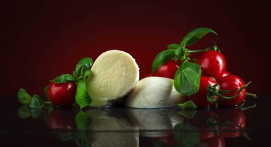 Mozzarella fesleğen ve siyah bir tabloda domates ile.