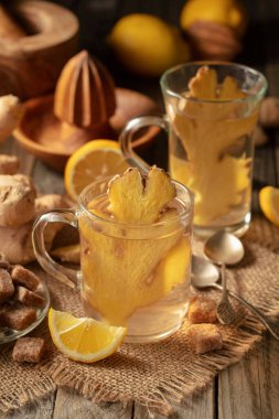 Malzemeli zencefil çayı. Eski ahşap bir masada zencefil, limon ve esmer şeker..