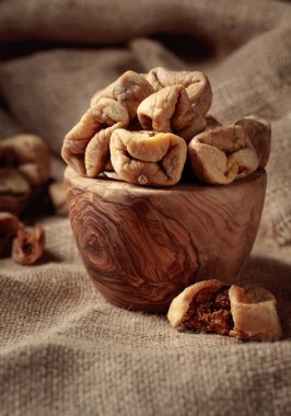 Çuval bezinde eski bir ahşap kapta kurutulmuş incir..