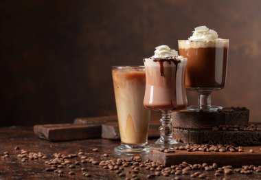 Kahverengi arka planda kremalı kahve ve çikolata içecekler. Cpoy alanı.