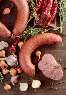 Ekmek, biberiye, soğan, sarımsak ve biberli eski ahşap bir masa sosisinde. Üst görünüm.