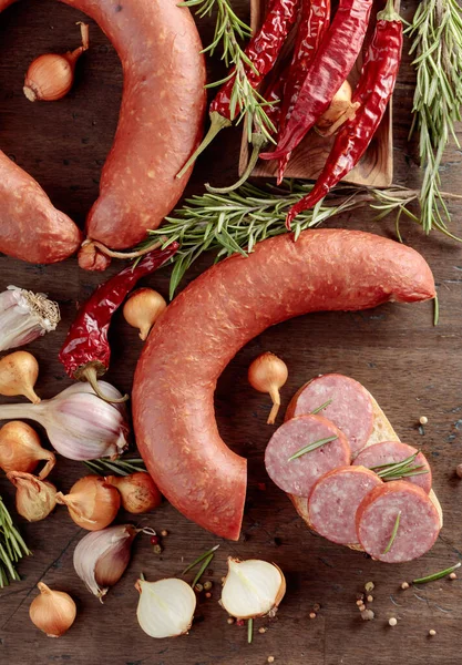 Ekmek, biberiye, soğan, sarımsak ve biberli eski ahşap bir masa sosisinde. Üst görünüm.