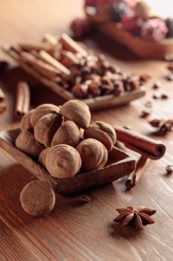 Tahta bir masada tarçın, anason ve kahve çekirdekli lezzetli çikolatalı trüf..