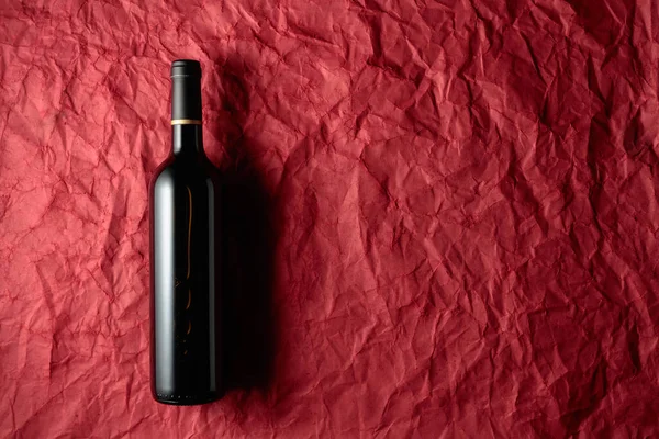 Bottle Red Wine Crumpled Red Paper Background Top View — Stock Photo, Image