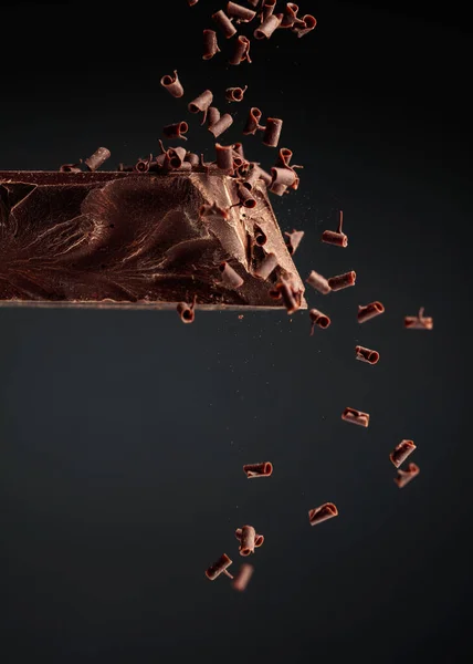 Großes Stück Dunkle Schokolade Und Fallende Schokoladenbrösel Auf Schwarzem Hintergrund — Stockfoto