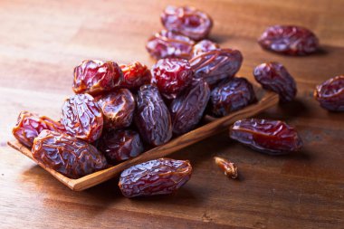 Eski ahşap bir masada sulu olgun tarihler.