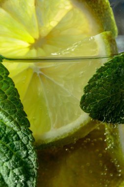 Karbonatlı içecek veya nane ve limon dilimli kokteyl..