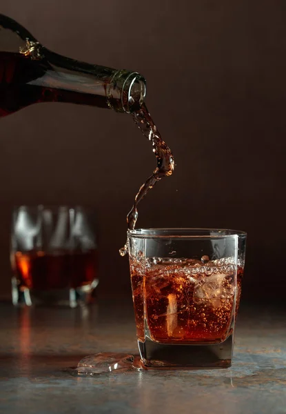 ウィスキーを瓶から氷を入れたフローズングラスに注ぐ 錆びた背景 — ストック写真