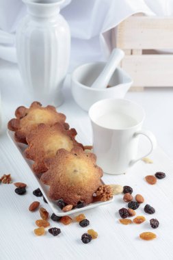 Mutfak masasında sütlü kekler. Beyaz ahşap bir masada ev yapımı üzümlü kek.. 