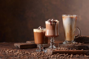 Kahverengi arka planda kremalı kahve ve çikolata içecekler. Cpoy alanı.