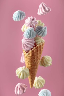 Pembe arka planda waffle külahında ev yapımı renkli krema..