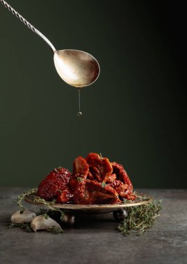 Taş bir masada güneşte kurutulmuş zeytinyağında domatesler. Boşluğu kopyala.