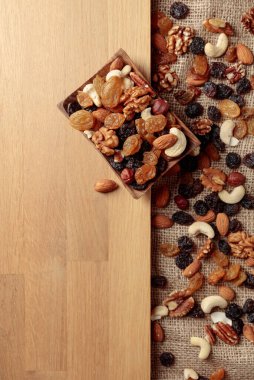 Kurutulmuş meyve ve fındık. Tahta bir masada fındık ve kuru üzüm karışımı. Kopyalama alanı olan üst görünüm.