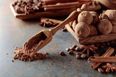 Çikolatalı trüf ve kakao tozlu kaşık. Antika bir masada tarçın, anason ve kahve çekirdekli şekerler..