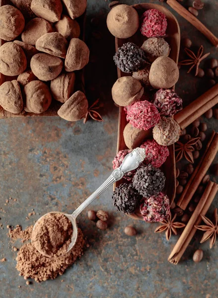 巧克力松露和勺子加可可粉 有肉桂 茴香和咖啡豆的糖果放在陈酿生锈的桌子上 顶部视图 — 图库照片