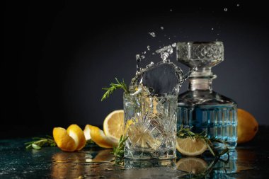 Limon ve biberiyeli cin tonik kokteyli. Limon dilimi bardağa dökülür Kokteylle.