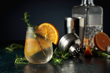Buzlu, portakallı ve biberiyeli cin tonik. Donmuş bardaktaki doğal buzla ferahlatıcı içecek..