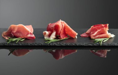Siyah yansıtıcı arka planda biberiyeli jambon..