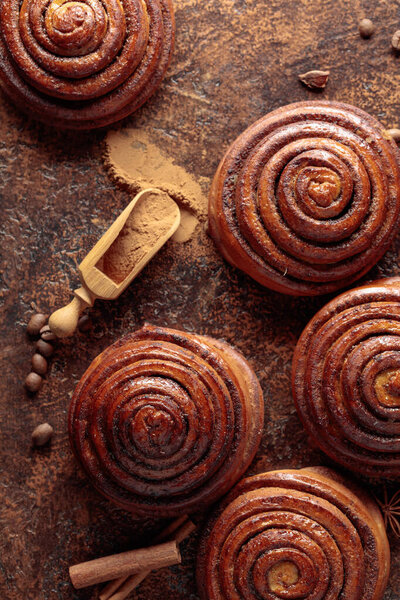 Булочки с корицей на кухонном столе. Вид сверху.