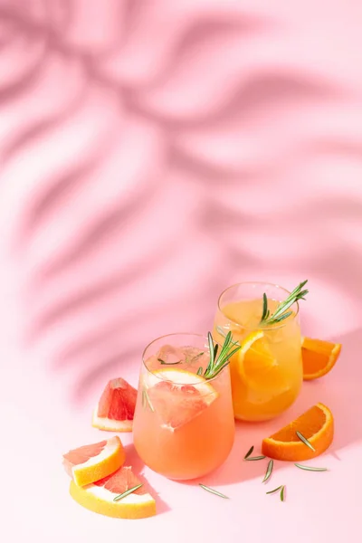 Летние Коктейли Грейпфрутом Апельсином Розмарином Льдом Напитки Розовом Фоне Пальмовым — стоковое фото