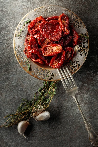 Zeytin yağında kurutulmuş domates kekik ve sarımsak eski bir taş masanın üzerinde. Üst görünüm.