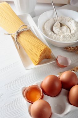 Beyaz ahşap bir masada malzemeli spagetti.. 