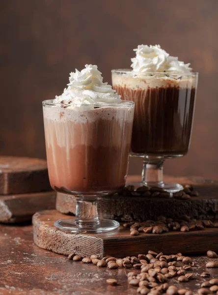 Kahverengi arka planda kremalı kahve ve çikolata içecekler..
