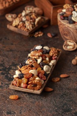 Kahverengi bir arka planda fındık ve kuru üzüm karışımı. Sunulan kuru üzüm, ceviz, fındık, ceviz, ceviz, ceviz ve badem..