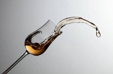 The drink spills out of the glass. Concept of the theme of premium alcohol. Copy space.