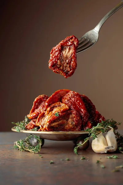 Taş bir masada güneşte kurutulmuş zeytinyağında domatesler. Boşluğu kopyala.