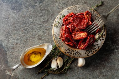 Zeytin yağında kurutulmuş domates kekik ve sarımsak eski bir taş masanın üzerinde. Üst görünüm.