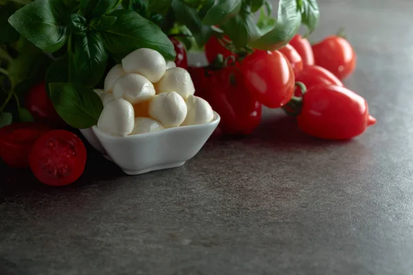 Eski bir taş masada fesleğen ve domatesli Mozzarella peyniri. Geleneksel İtalyan yemeği. Boşluğu kopyala.
