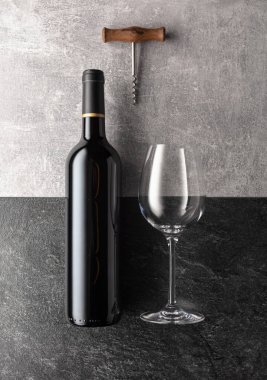 Taş zeminde bir şişe kırmızı şarap. Üst görünüm.