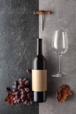 Arka planda üzümlü kırmızı şarap. Boş bir şişede. Üst görünüm.