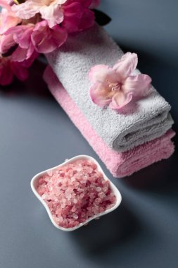 Pembe Himalaya tuzu, çiçeği ve havlusuyla spa kompozisyonu.