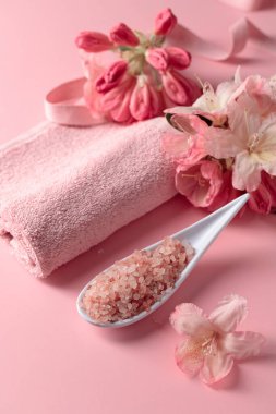 Pembe Himalaya tuzu, çiçeği ve havlusuyla spa kompozisyonu.