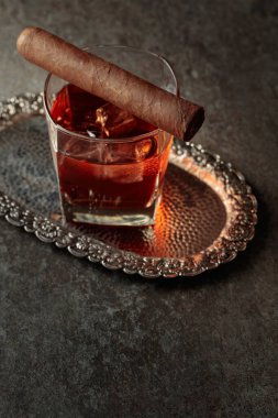 Buzlu viski ve puro eski bir taş masada. Boşluğu kopyala.