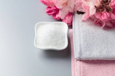 Deniz tuzu, çiçek ve havluyla spa kompozisyonu. Boşluğu kopyala.
