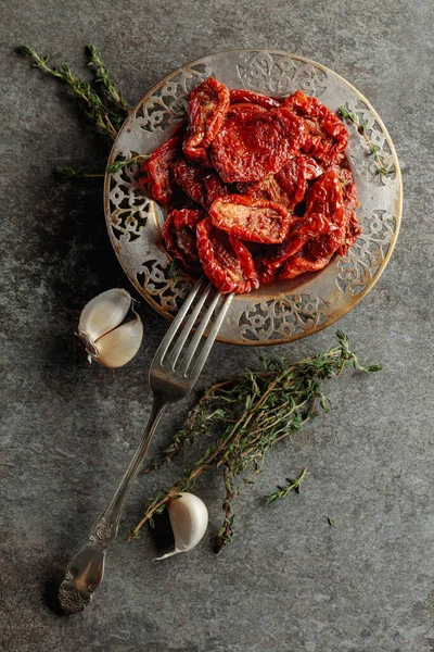 Zeytin yağında kurutulmuş domates kekik ve sarımsak eski bir taş masanın üzerinde. Üst görünüm.