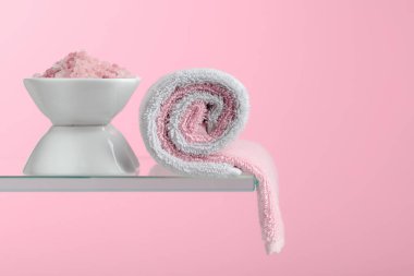 Pembe arka planda pembe tuz ve havlu içeren spa kompozisyonu. Boşluğu kopyala.
