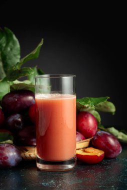 Taze mor erikli bir masada bir bardak erik suyu. Boşluğu kopyala.