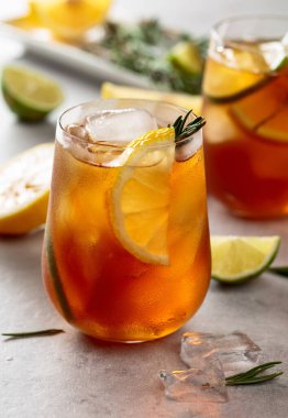 Limonlu buzlu çay, limon ve biberiye dallarıyla süslenmiş buz. Turunçgil dilimli donmuş bardaklar..