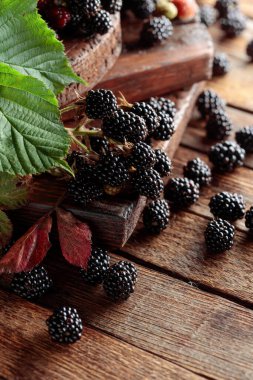 Eski ahşap bir masada taze böğürtlen.