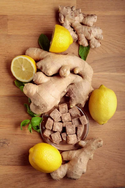 Ginger, lemon, mint and brown sugar on a old wooden table.