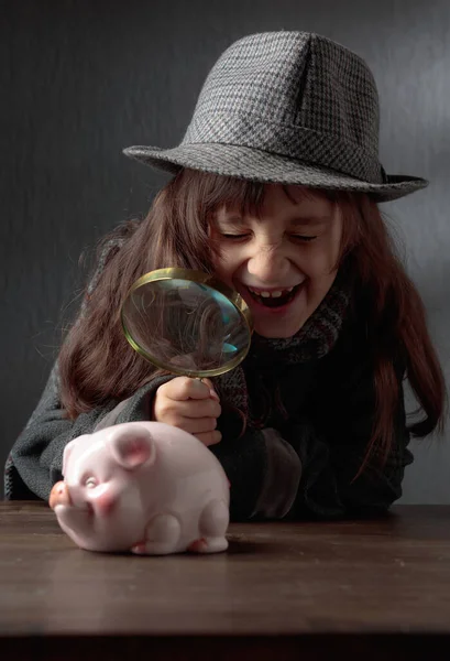 Cute Little Detective Magnifying Glass Looks Piggy Bank Little Girl — Stock Photo, Image
